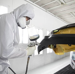Collision Center Technician Painting a Vehicle | DARCARS Toyota of Baltimore in Baltimore MD