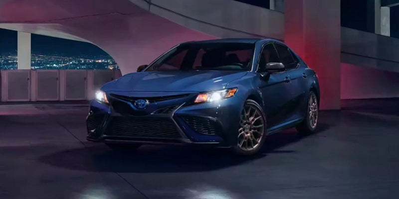 2024 Toyota Camry Hybrid in Blue Driving at Night Baltimore, MD